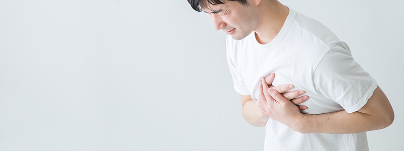 心臓の痛みを感じている男性の画像