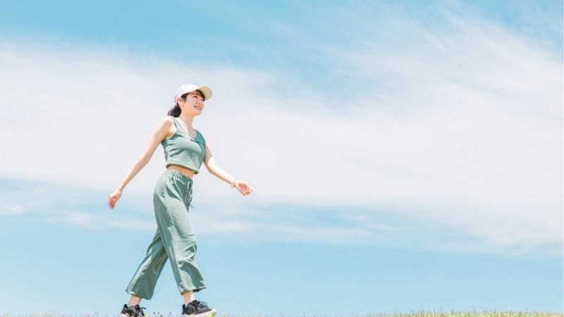 青空の下で運動している女性